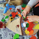 na zdjęciu widać ręce kobiety wykonujące prace plastyczne jesienna dekoracje do biblioteki