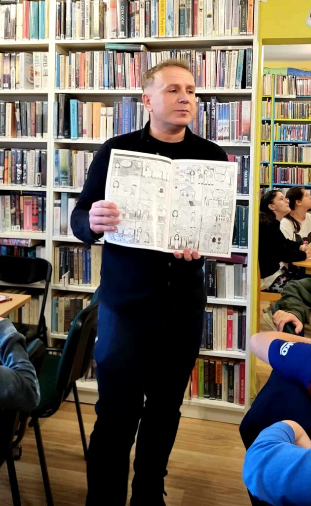 na zdjęciu widać mężczyznę trzymającego książkę