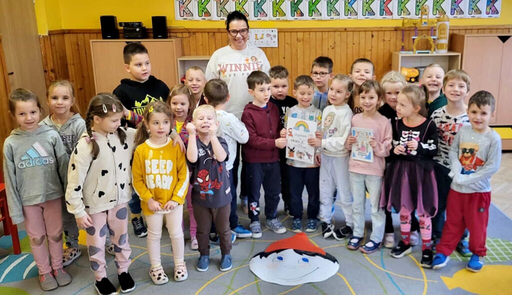 na zdjęciu widać stojące dzieci w wieku przedszkolnym w sali przedszkolnej