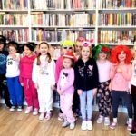 na zdjęciu widać dzieci w sali bibliotecznej w kolorowych nakryciach głowy