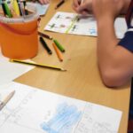 na zdjęciu widać rysunek oraz malującego chłopca