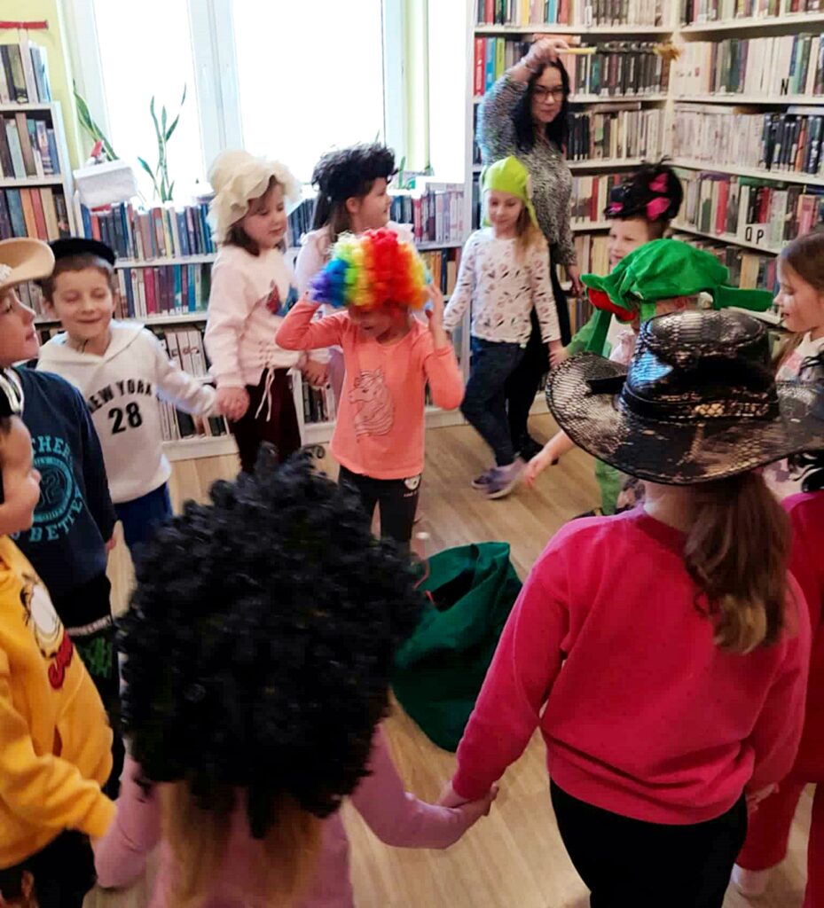 na zdjęciu widać tańczące dzieci w sali bibliotecznej