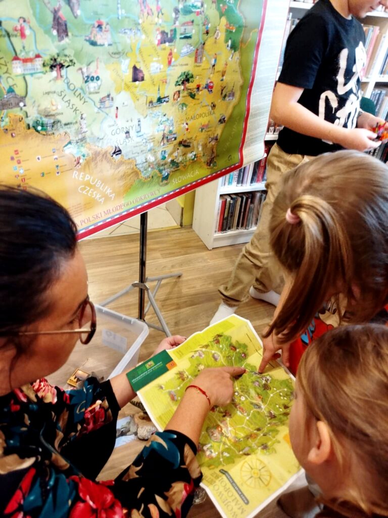 Na zdjęciu widać dzieci wpatrzone w mapę