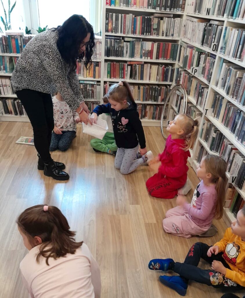 na zdjęciu widać dzieci siedzące na podłodze