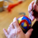 Na zdjęciu widać kolorową bańkę którą wykonuje na zajęciach pani seniorka uczestnicząca w zajęciach bibliotecznych