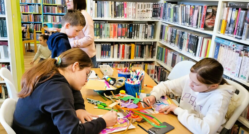 na zdjęciu widać dzieci przy stole kolorujące