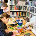 na zdjęciu widać dzieci przy stole kolorujące