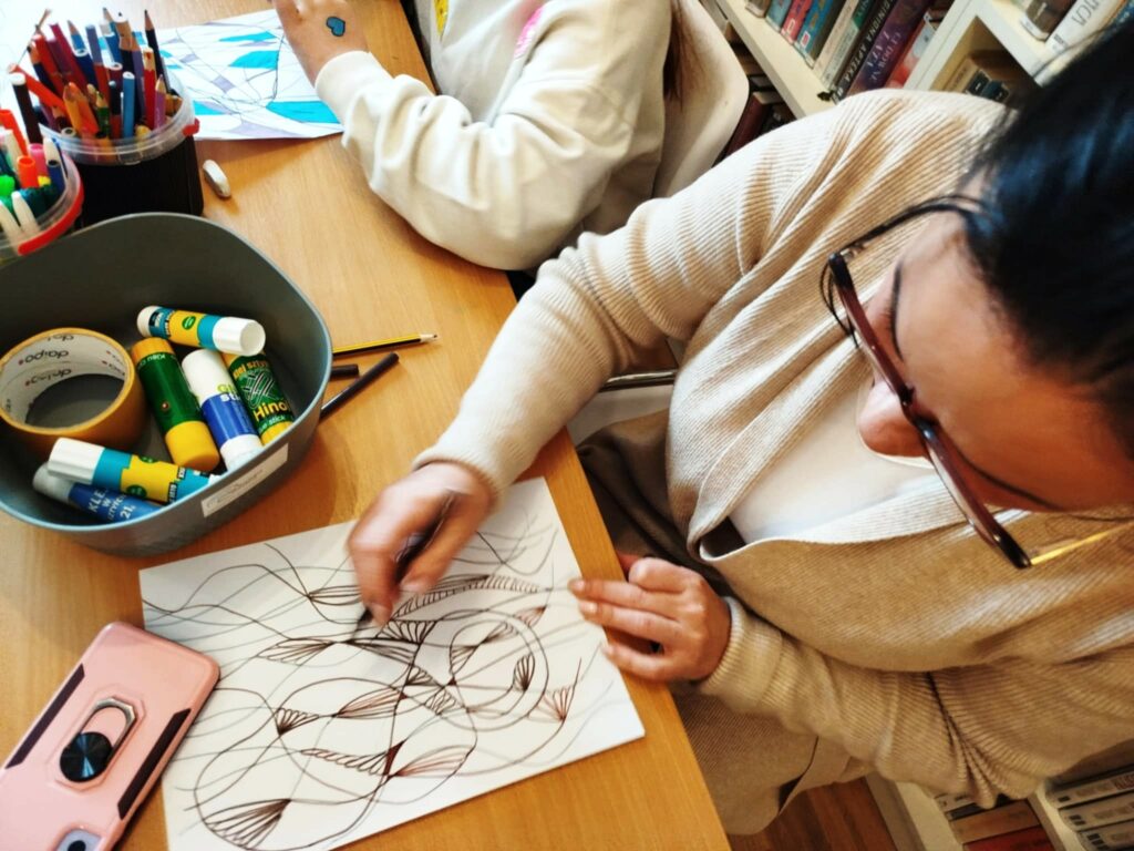 na zdjęciu widać dzieci przy stole kolorujące