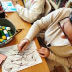 na zdjęciu widać dzieci przy stole kolorujące