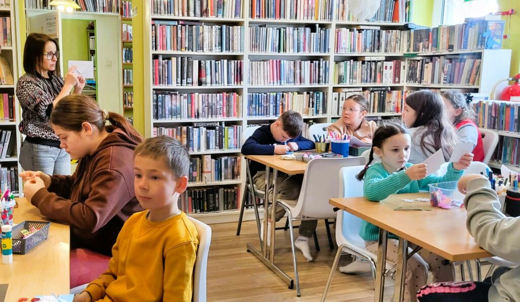 na zdjęciu widać dzieci w sali bibliotecznej