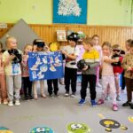 na zdjęciu grupa dzieci w wieku przedszkolnym ustawiona do wspólnego zdjęcia. Niektóre trzymaja w ręku akcesoria sportowe miedzy innymi kask na głowe , gogle , rękawice