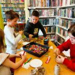 na zdjęciu widać dzieci przy stole tworzące prace plastyczne