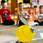 na zdjęciu widać balonową pszczołę a za nią siedzących chłopców