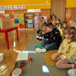 na zdjęciu widać dzieci w wieku przedszkolnym siedzących na podłodze