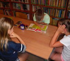 uczestnicy bibliotecznych zajęć słuchają dzisiejszej opowieści czytanej przez jednego z chłopców