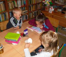 uczestnicy zajęć z uwagą słuchają opowieści czytanej przez jedną z dziewczynek