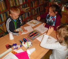 dzieci z zaangażowaniem kolorują swoje karuzelowe koniki