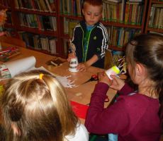 dzieci ozdabiają kolorowymi papierami podstawę swoich karuzel