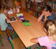 dzieci słuchają dzisiejszej opowieści czytanej przez jedną z dziewczynek