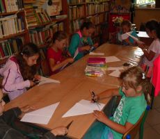 dzieci w skupieniu wycinają i składają kartki do dzisiejszej pracy