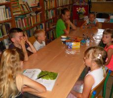 dzieci z uwagą słuchają dzisiejszej porcji ciekawostek czytanej przez jedną z dziewczynek