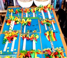 na zdjęciu widać poukładane na stole prace plastyczne, wykonane przez dzieci.